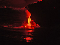 Mt. Kilauea. Small “firehose” from jutting point prominent this image. Note shower of water falling along hose after latest wave. Height of hose in this view, about 2 m.