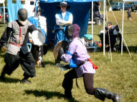 Russell, in gray midieval outfit, enjoys a sunny afternoon match.