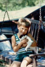 Joe with a cat on the swing in 1986